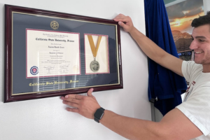 smiling man hanging medal diploma frame
