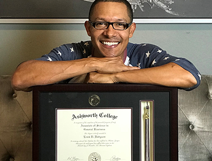 Smiling alumni who found a diploma frame with tassel to finally hold his diploma in