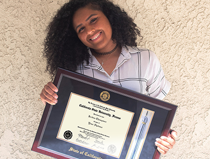 Happy young woman holding a custom State of California diploma frame with tassel