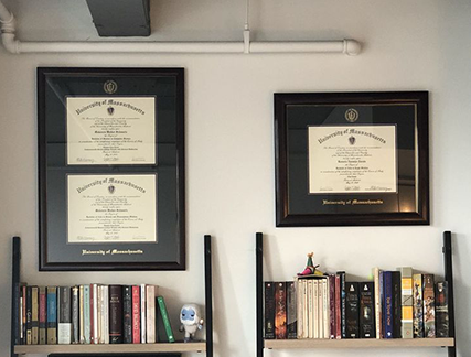 Double Document diploma frame next to sing document diploma frame over bookshelf