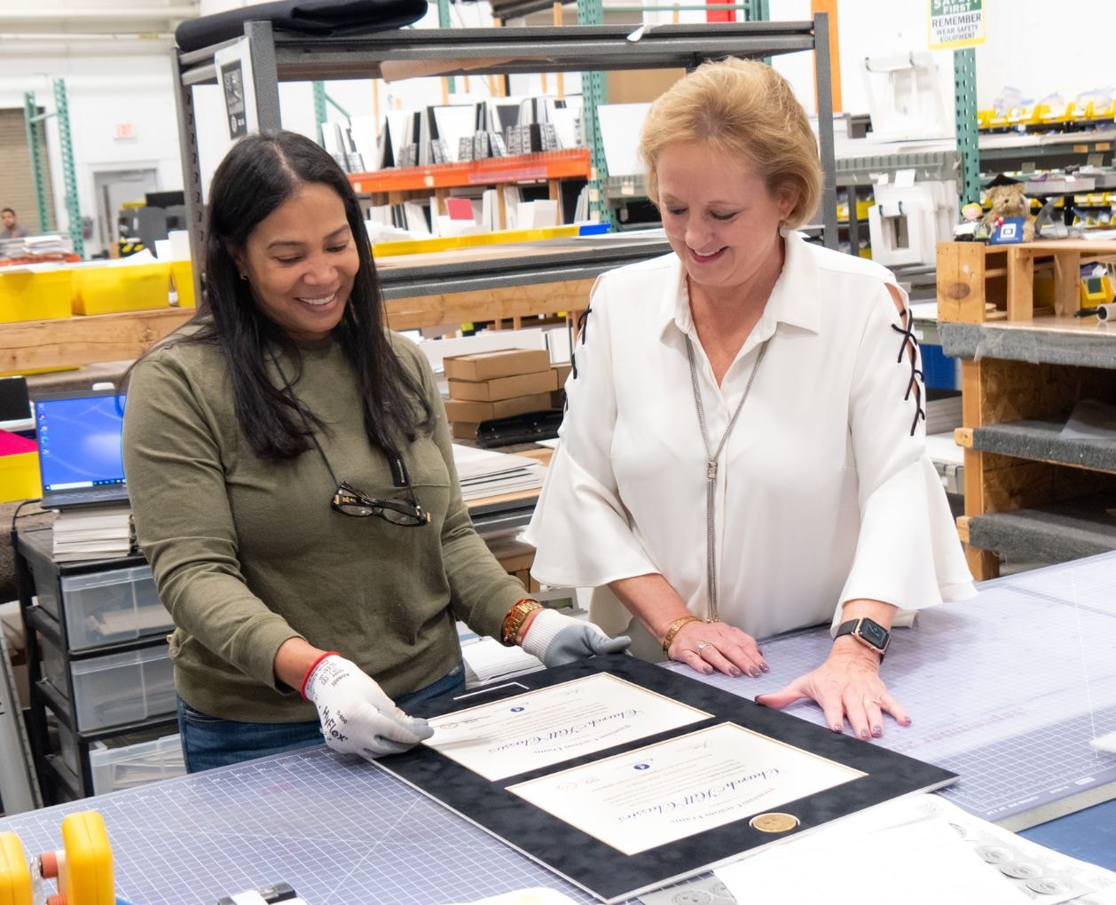 Lucie and employee working on double diploma frame