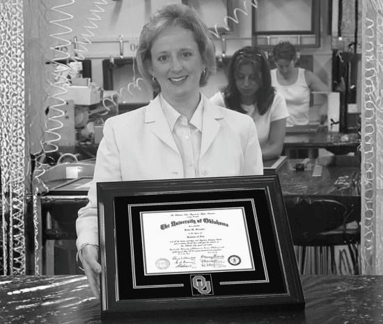 Lucie Voves holding a University of Oklahoma diploma frame