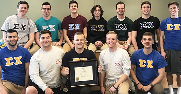 Group of 12 Sigma Chi fraternity brothers holding a certificate frame.