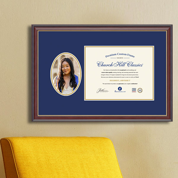 diploma frame with oval portrait photo hanging on a wall above yellow chair