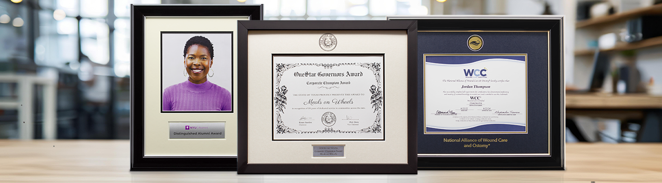 Three custom corporate award frames displayed on a desk