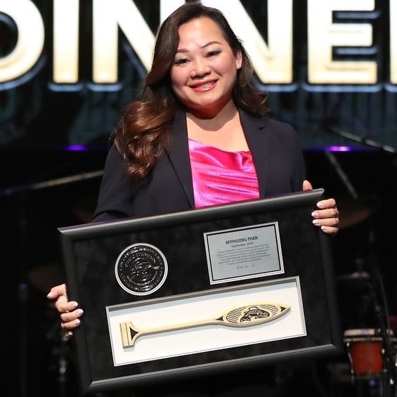 Woman holding years of service award recognition frame