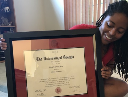 College graduate holding her custom diploma frame
