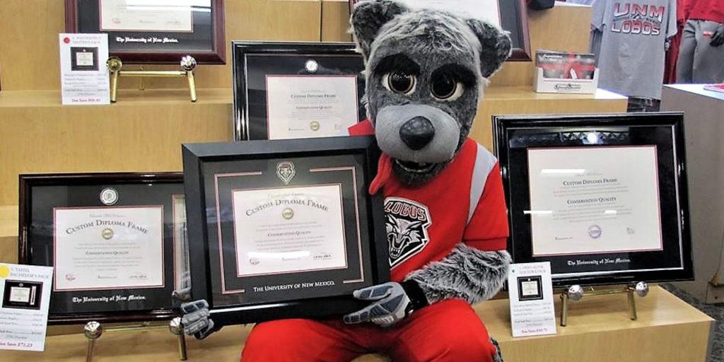 UNM lobo holding diploma frame in bookstore
