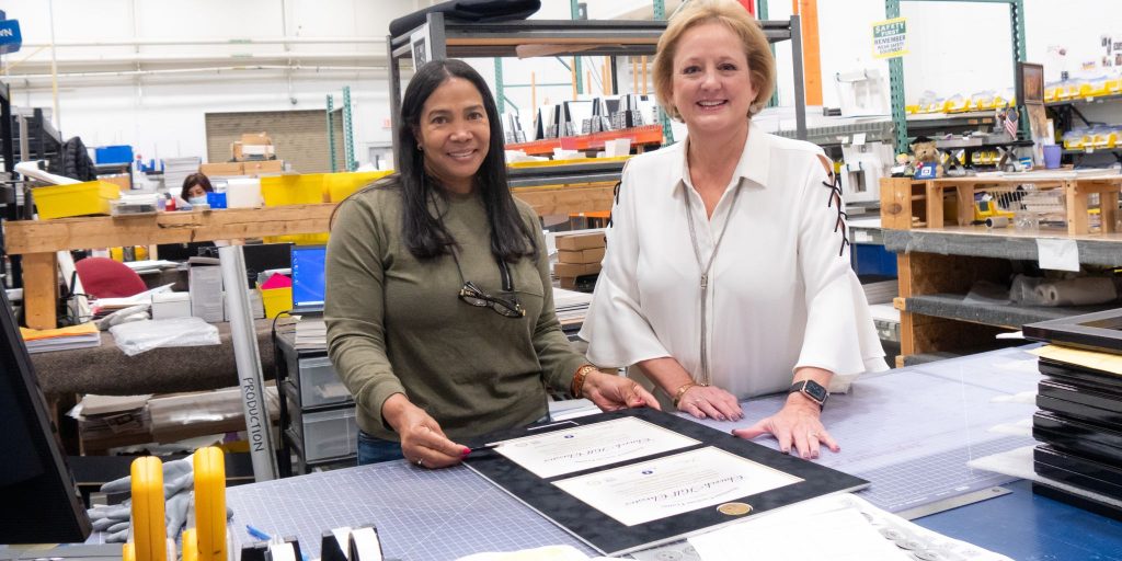 women constructing custom double diploma frame