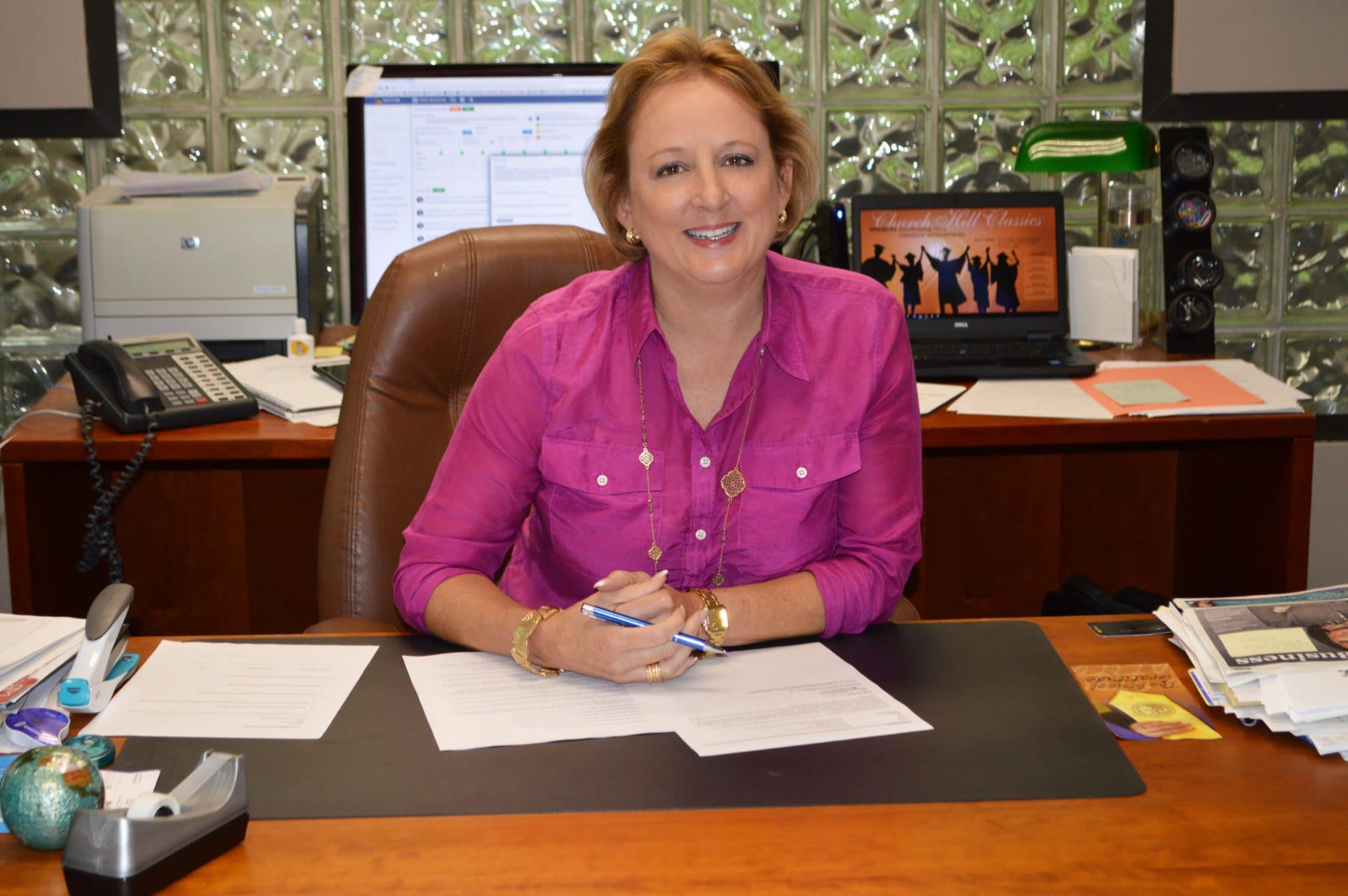 ceo lucie voves sits at desk in pink shirt
