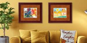 gold living room with children's artwork in frames with orange suede mats
