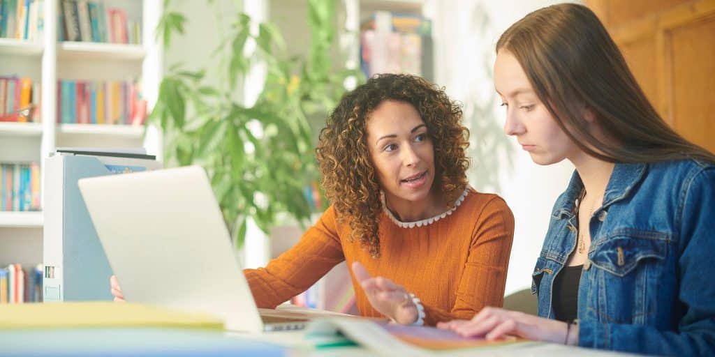 guidance counselor with student at laptop