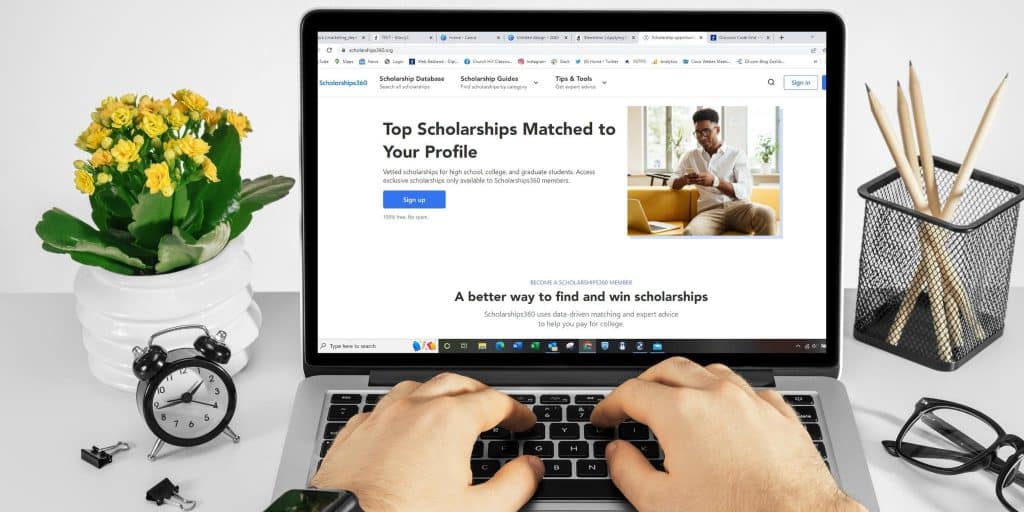 hands on laptop searching for scholarships