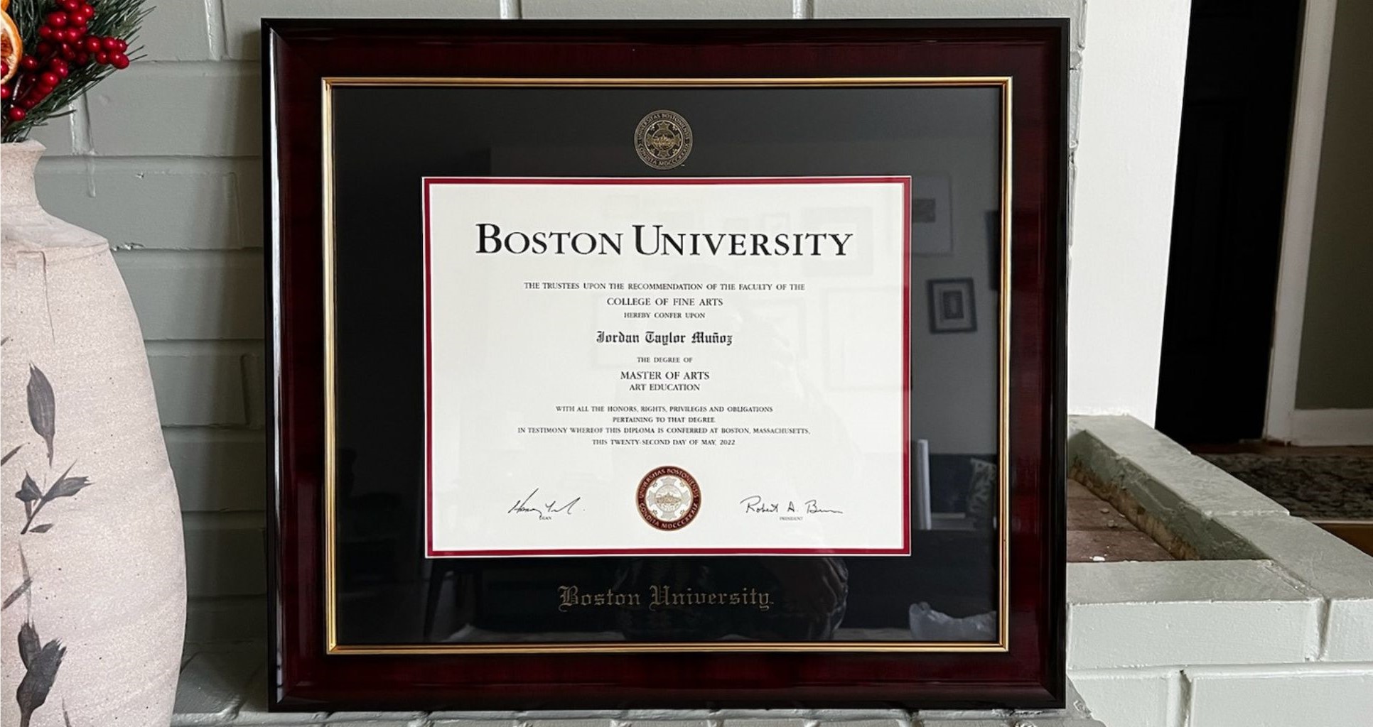 Boston University diploma frame on white brick shelf