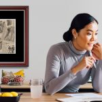 woman at desk with framed historic newspaper clipping on wall