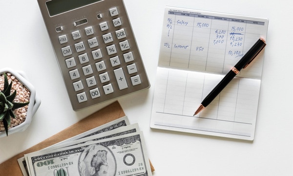 closeup of calculator and checkbook on desk