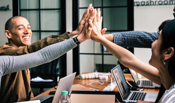 coworkers highfiving in office