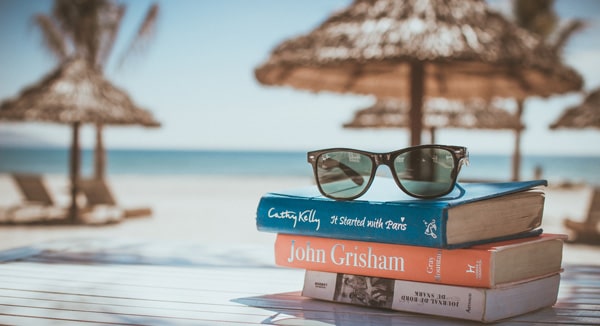 books and sunglasses on table on beach