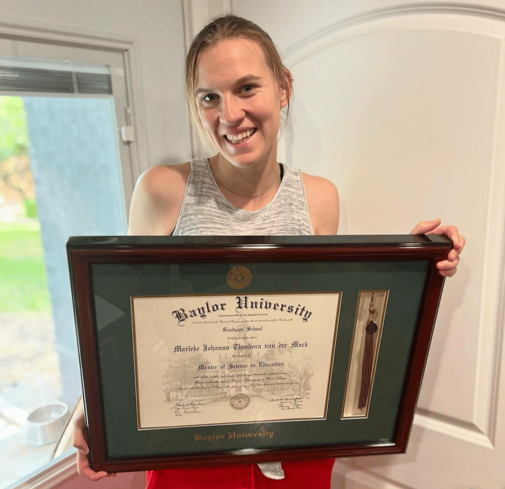 female grad holding baylor frame