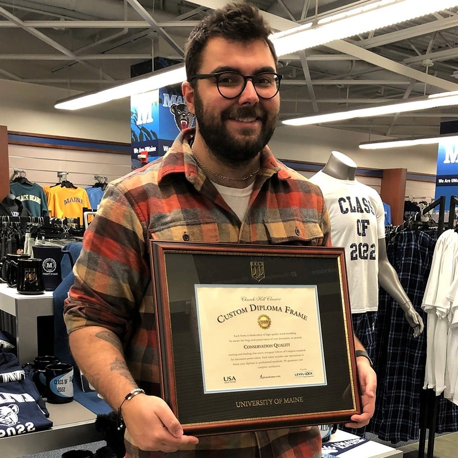 man holding u of maine diploma frame