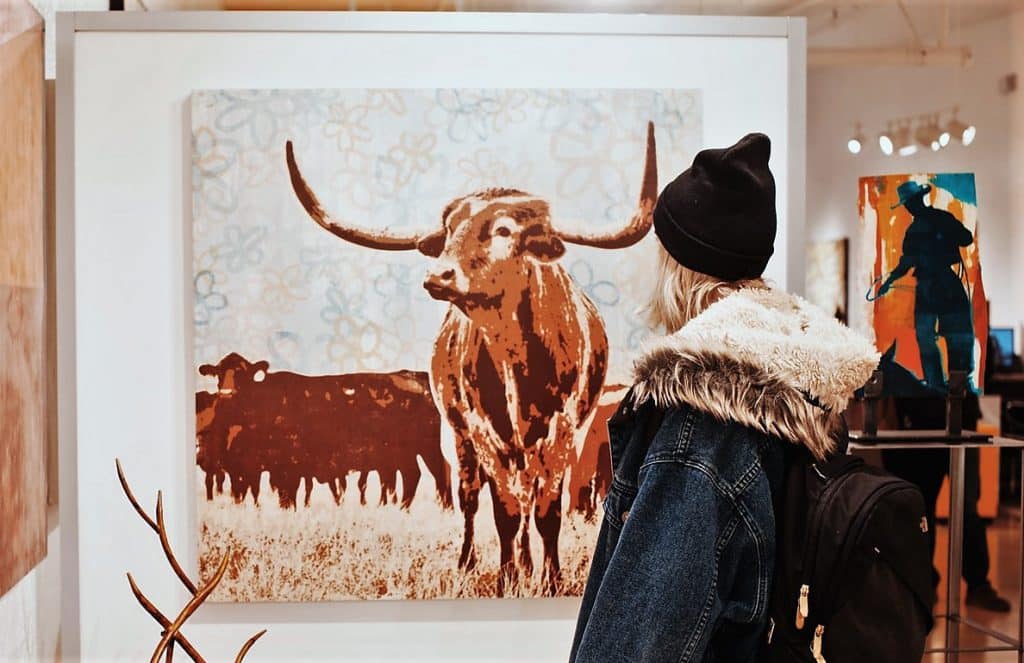woman staring at float mount bull artwork