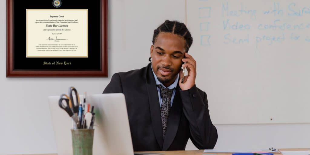 man on phone with state bar certificate frame