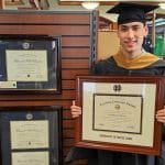 grad in bookstore holding notre dame diploma frame