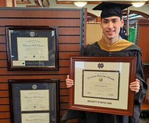 grad in bookstore holding notre dame diploma frame