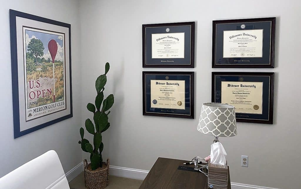 home office with four diploma frames on wall