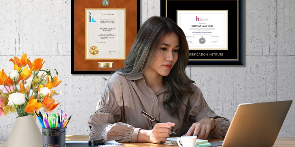 woman at desk with pen in hand looking at laptop