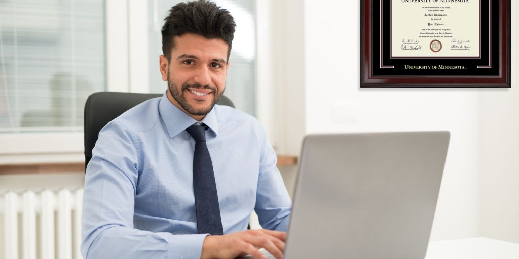 young man in tie at desk with university of missouri frame in office