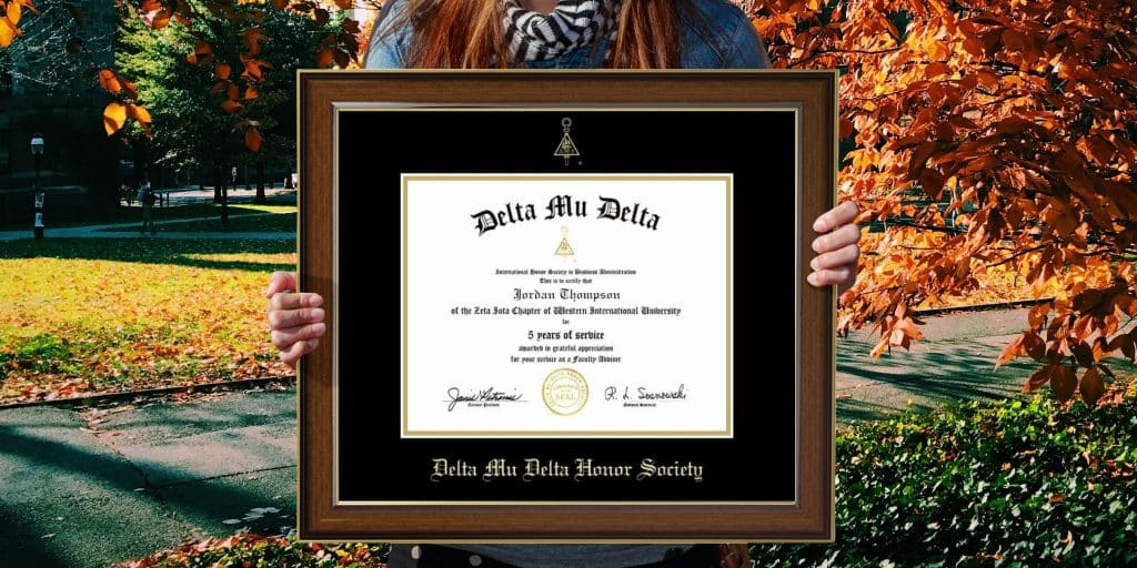 hands holding a delta mu delta certificate frame