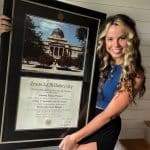 girl holding texas a&m diploma frame