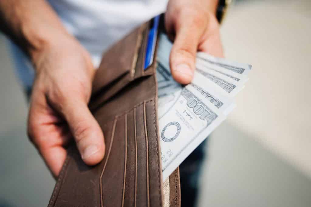 closeup of hands taking money out of wallet