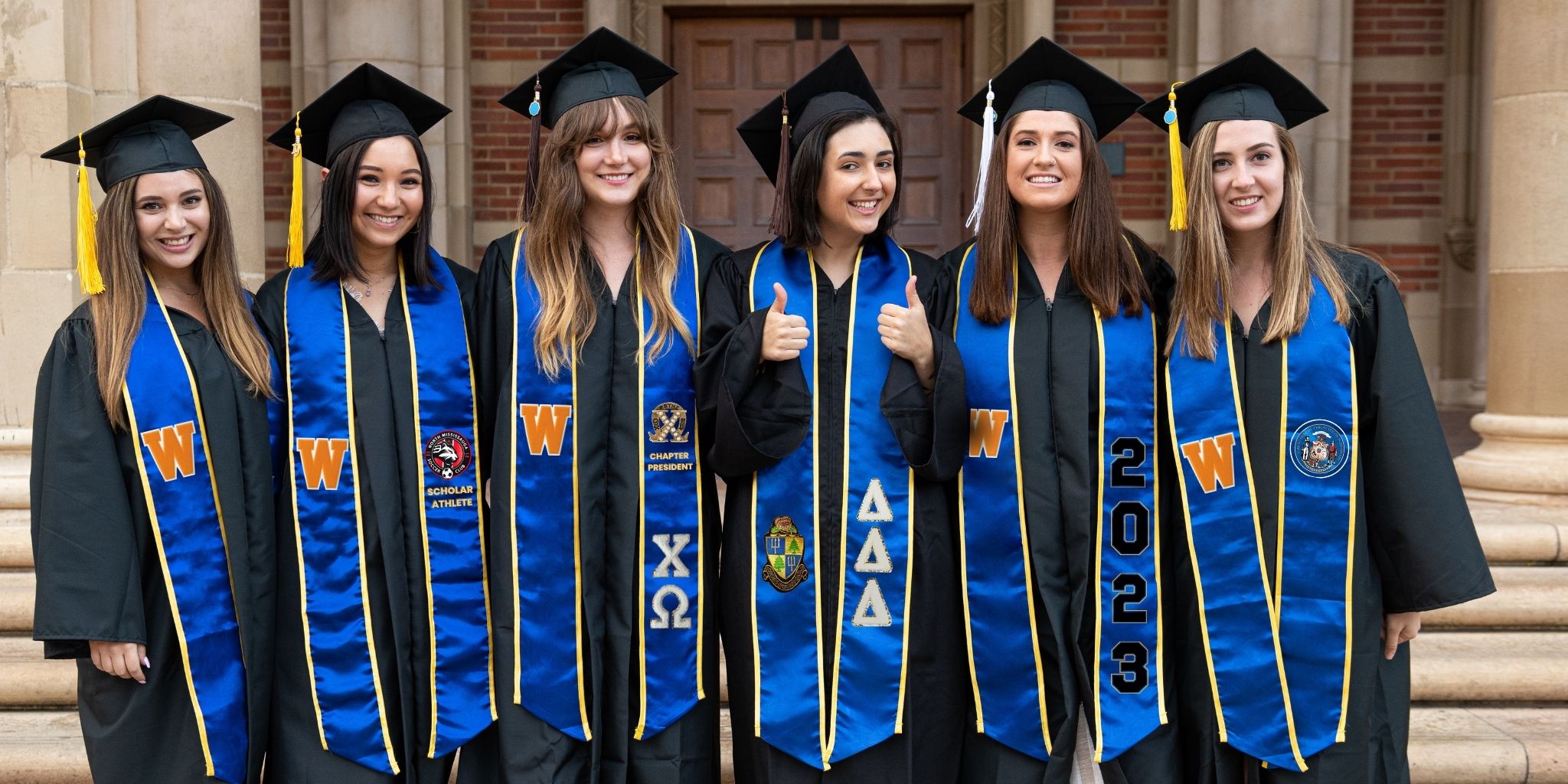 six graduates wearing blue graduation stoles