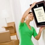 woman hanging her diploma frame on wall