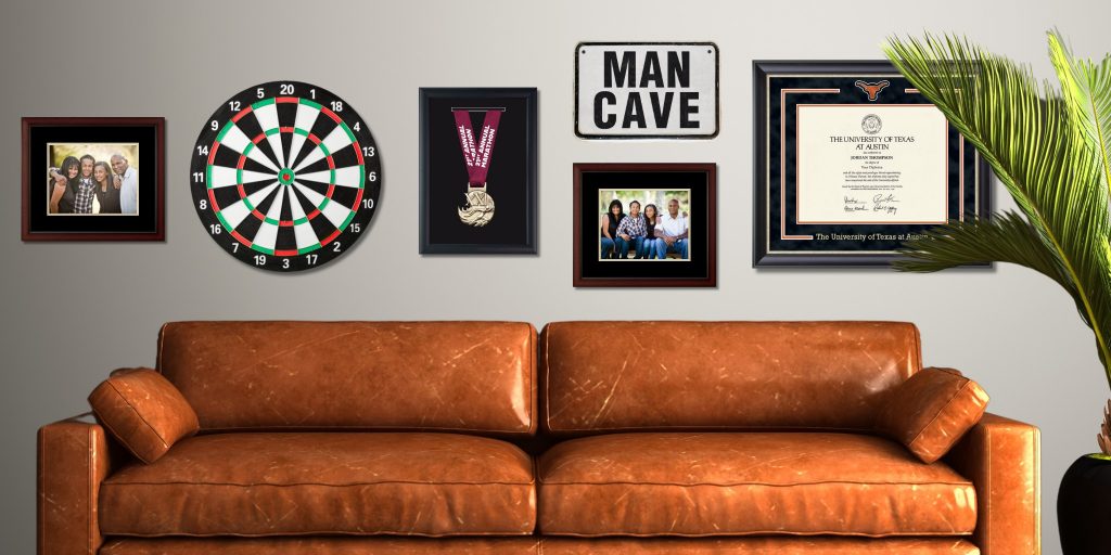 custom photo frame, marathon medal frame, dartboard, and UT Austin diploma frame on wall above orange couch