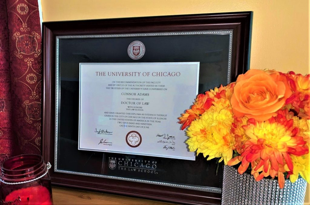 University of Chicago Law School Diploma frame next to bright flowers