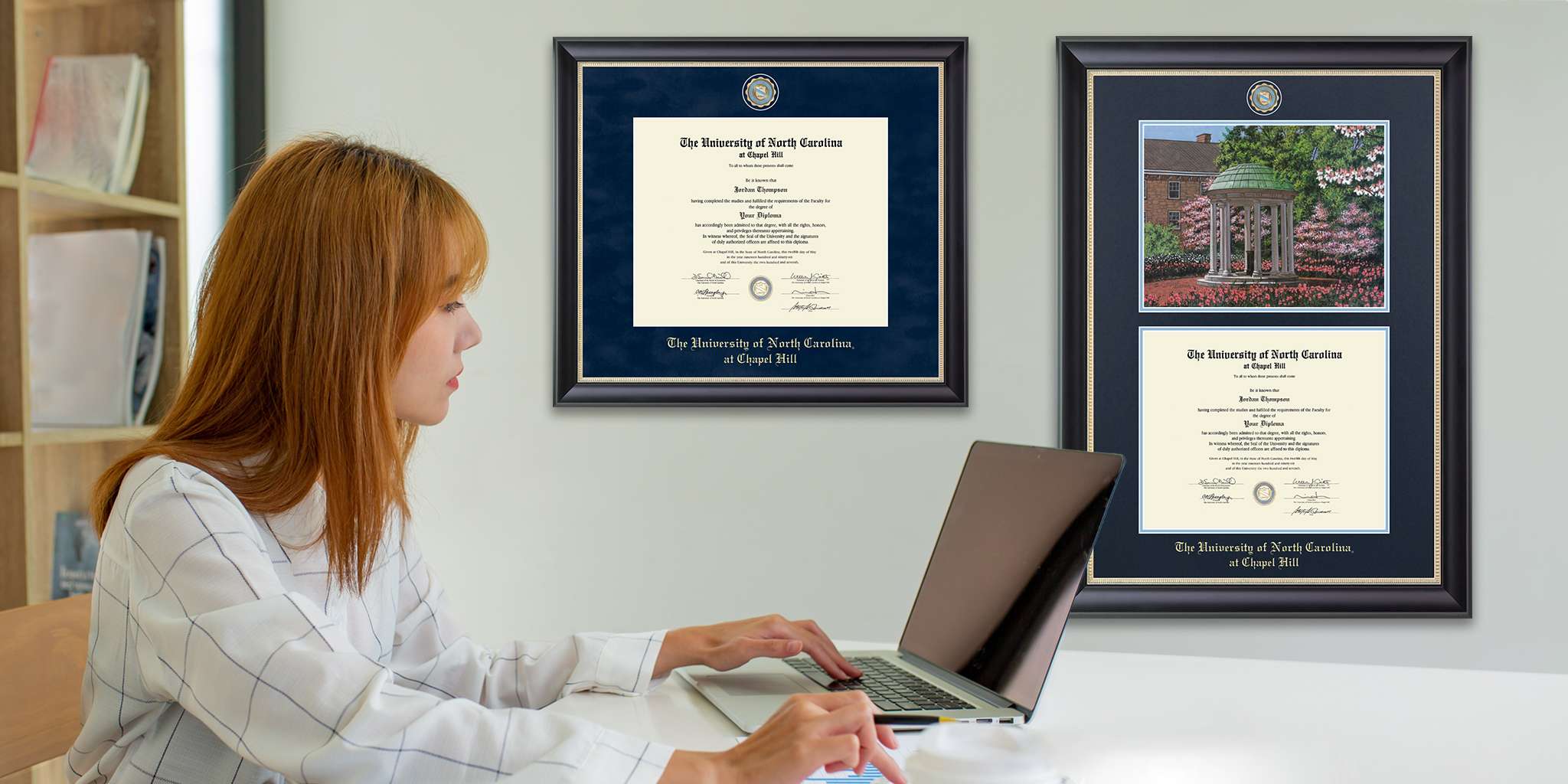 woman working on computer with custom diploma frames hung on wall in office