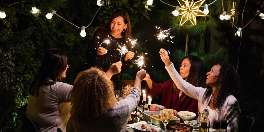 ladies holding sparklers at outdoor dinner party