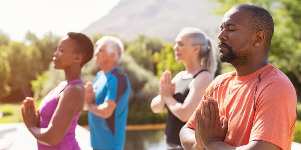 people in lotus pose outdoors