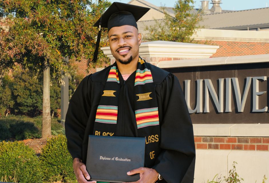 graduate in regalia holding university diploma cover