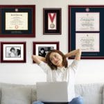 woman on couch with diploma frames on wall