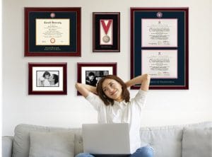 woman on couch with diploma frames on wall