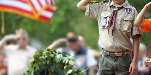 scout dressed in boy scout uniform saluting toward camera
