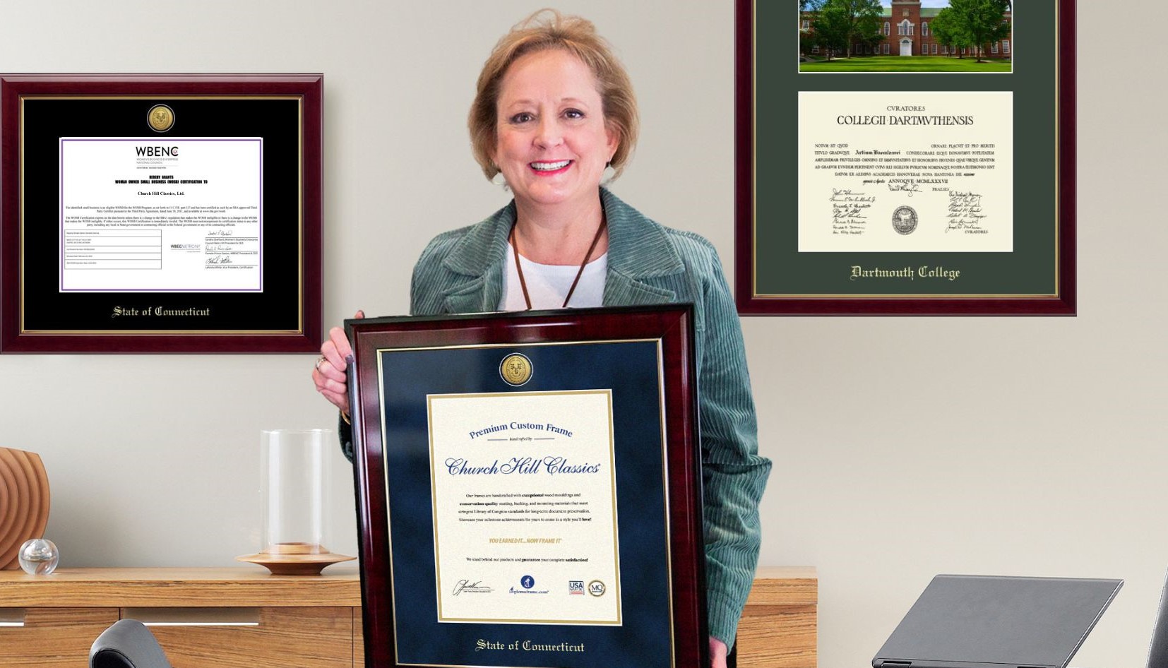 Lucie Voves holding State of Connecticut certificate frame in office