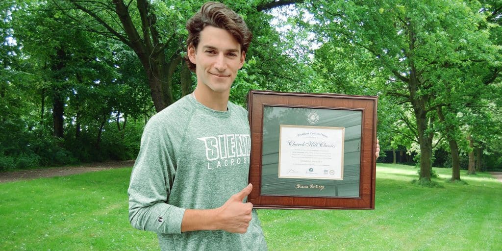 college senior holding siena college frame