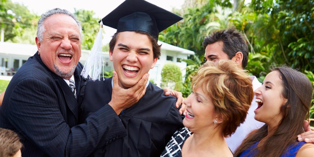 family smiling around male graduate