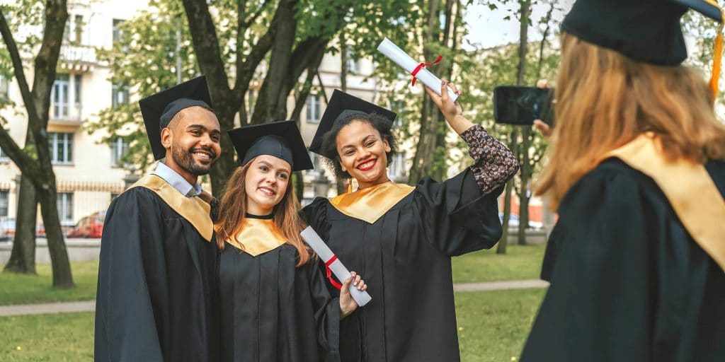 three graduates posing for picture in regalia
