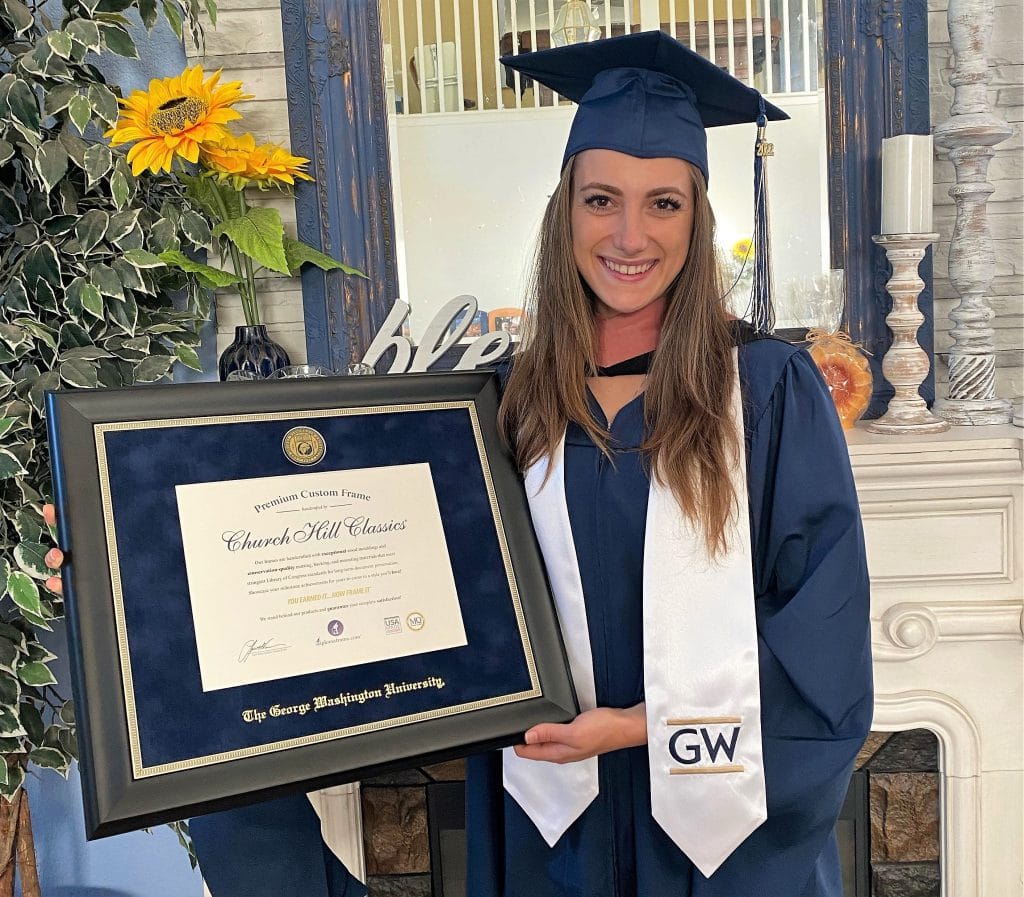 grad holding her gwu diploma frame